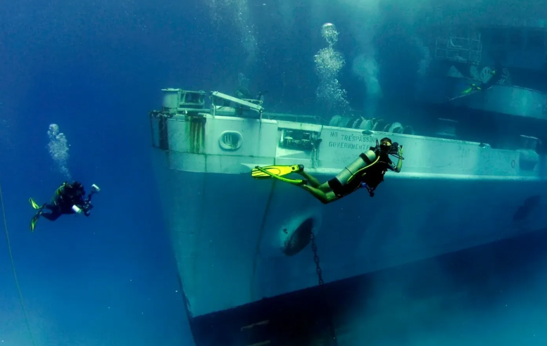 Marine technician checking a reef monitoring camera before a dive